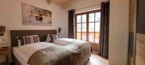 een slaapkamer met een bed en een groot raam bij Hochalmbahnen Chalets Rauris 1-20 WE4, Maislaufeldweg 1r OG in Rauris