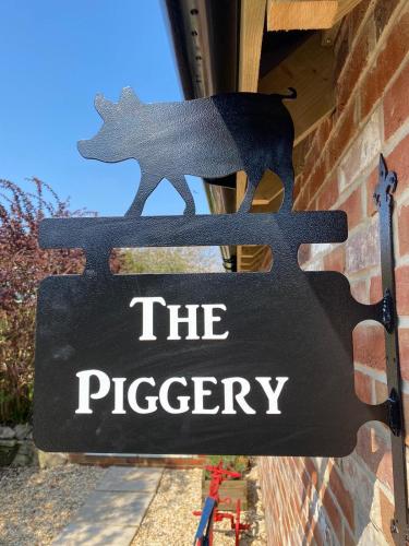 a sign that reads the pipery on a building at The Piggery at the Cottage in Wool