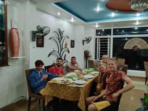a group of people sitting around a dinner table at Mountain Pearl Hotel in Cat Ba