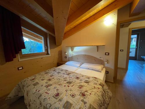 a bedroom with a bed in a room with a window at Casa del Roccolo in Folgarida