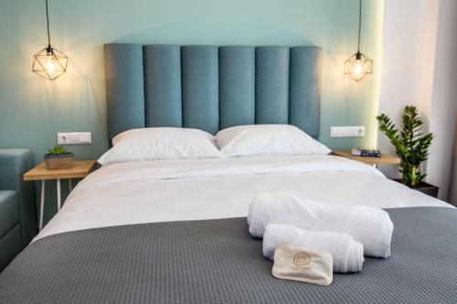 a bedroom with a large bed with towels on the floor at New Azzurro Deluxe in Limenaria