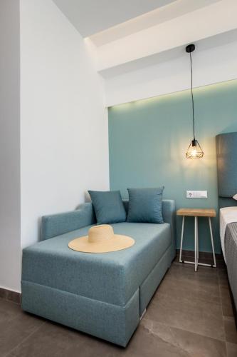 a living room with a blue couch and a table at New Azzurro Deluxe in Limenaria