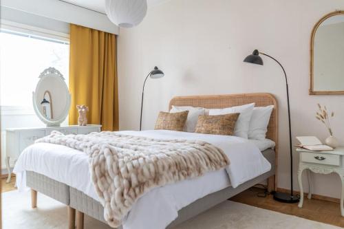 1 dormitorio blanco con 1 cama grande con manta en 1br apartment in Leppävaara with balcony and sauna, en Espoo