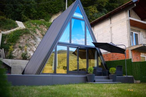 a house with a pyramid shaped window in the yard at Unique Lake House Paradiso in Zvornik