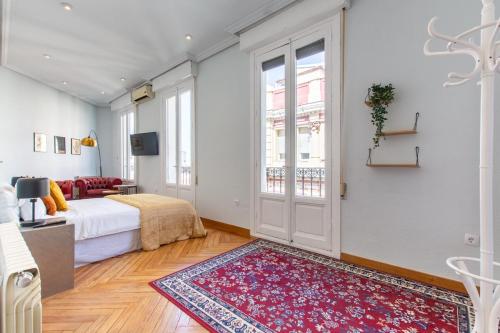 a bedroom with a bed and a door with a rug at Impresionantes vistas Skyline Madrid in Madrid