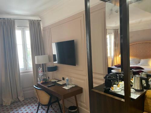 a hotel room with a desk and a bed and a mirror at Grand Hotel de l'Opera - BW Premier Collection in Toulouse