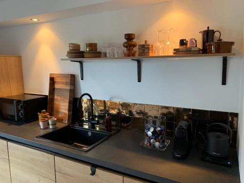 a kitchen with a sink and a counter top at B&B Loft-13 in Opende