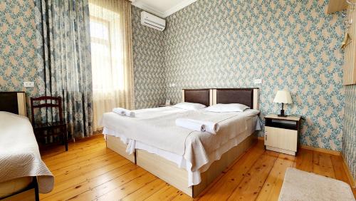 a bedroom with a large bed with blue wallpaper at HOTEL JULIA Akhaltsikhe in Akhaltsikhe