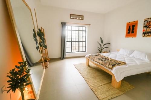 una camera con letto e specchio di Cozy Stays Kigali a Kigali