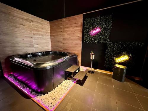 bañera con luces moradas en una habitación en Homelove Spa en Neuilly-en-Thelle