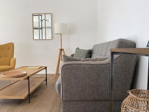 a living room with a couch and a table at Verde Salvia Home - Free park in Tavernerio