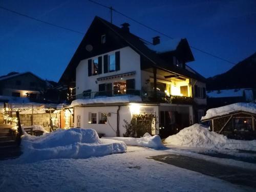 a house is covered in snow at night at Studio Holunder Weissbriach in Weissbriach