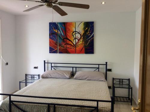 1 dormitorio con 1 cama con una pintura en la pared en Rocas del Mar with heated Pool and double Terrace en Costa del Silencio