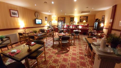 a restaurant with tables and chairs in a room at Hôtel 1er Consul Rouen in Rouen