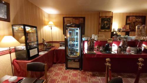 a restaurant with a counter and a refrigerator with food at Hôtel 1er Consul Rouen in Rouen