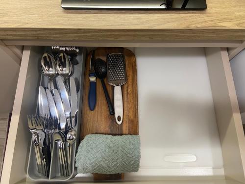 a drawer in a cabinet filled with utensils at Smart Home , Lovely Apartment in Tirana in Tirana