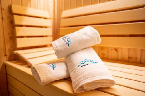 due asciugamani laminati seduti su una panchina in una sauna di Apart Invest Centrum Park 13 a Szklarska Poręba