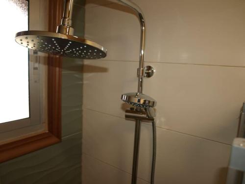 y baño con ducha con cabezal de ducha. en Apartamento con terraza y vistas al mar, en Bueu