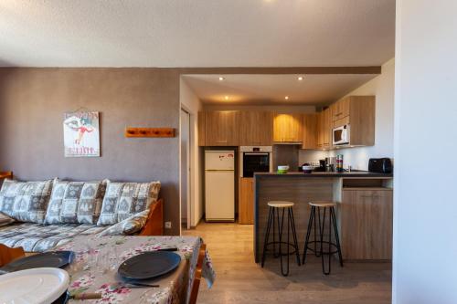 un salon avec un canapé et une cuisine dans l'établissement Le Corbier de Colette, à Villarembert