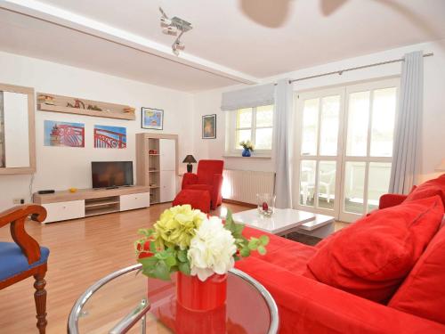 uma sala de estar com um sofá vermelho e cadeiras vermelhas em Villa Freya - Apt. 06 em Ostseebad Sellin