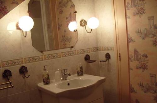 uma casa de banho com um lavatório e um espelho em Les Puits Bessin Normandie em Sommervieu