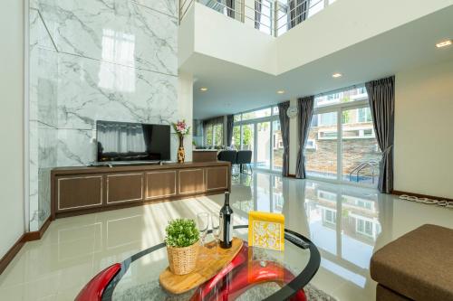 a living room with a table and a tv at Luxury Pool Villa at Golden Sea Hua Hin in Hua Hin