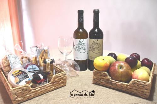 two baskets of fruit and wine bottles on a table at La Casita de Tila in Ifonche