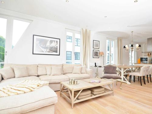 a white living room with a white couch and a table at Villa Johanna in Sellin - WG 13 mit Kamin und zwei Balkonen in Ostseebad Sellin