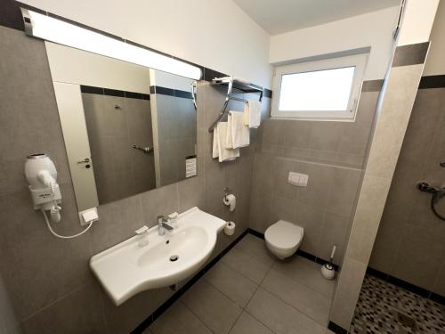 a bathroom with a sink and a toilet at Aparthotel Neudörfl in Neudörfl