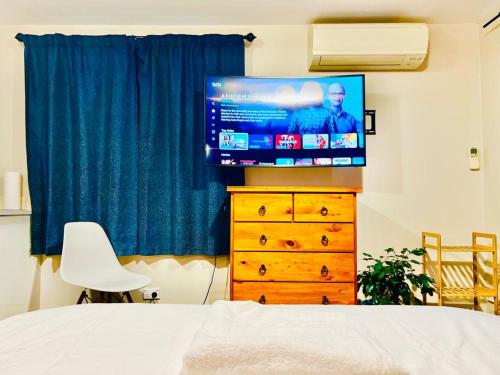 um quarto com uma cama e uma televisão numa cómoda em Private studio Auckland Self Checkin and 2 Parking Netflix Prime em Auckland