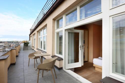 a balcony with tables and chairs on a building at Amarilis in Prague