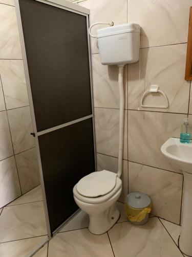 a bathroom with a toilet and a sink at Central Chalés in Cambará