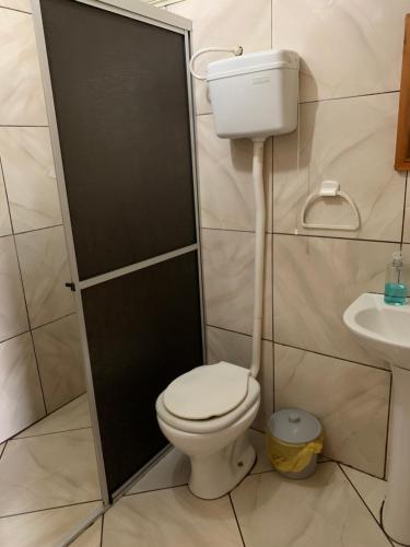 a bathroom with a toilet and a sink at Central Chalés in Cambara do Sul