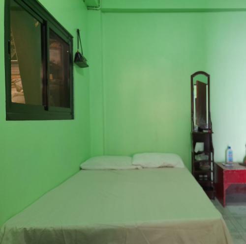 una camera da letto con un letto bianco e uno specchio di CJ Transient house a Baguio