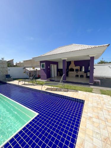a villa with a swimming pool and a house at casa de praia com piscina e hidromassagem in Arraial do Cabo