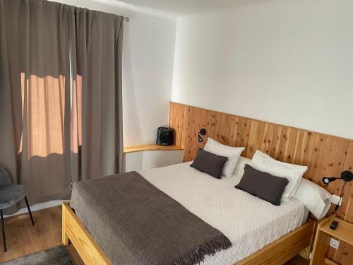um quarto com uma cama grande e 2 almofadas em Vila Rosario em Ponta Delgada