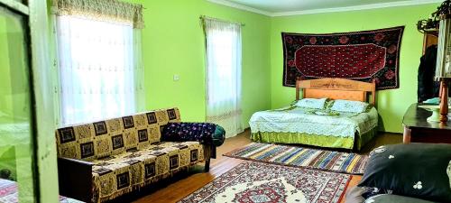 a green room with a bed and a bed and a couch at Papi Aygi in Alaverdi