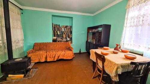 Schlafzimmer mit 2 Tischen und einem Bett mit orangefarbener Bettwäsche in der Unterkunft Papi Aygi in Alawerdi