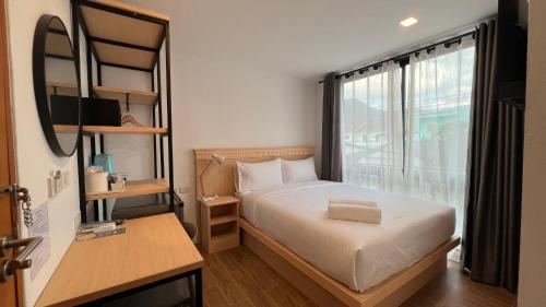 a small bedroom with a bed and a window at B3 HOUSE in Kamala Beach