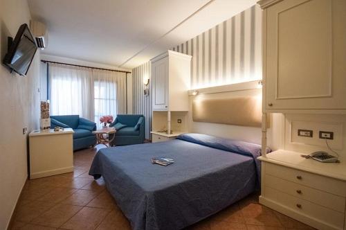 a hotel room with a bed and a living room at Hotel Barsalini in SantʼAndrea