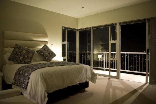 a bedroom with a bed and a balcony at Orangerie Guest House in Johannesburg