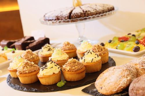 a bunch of cupcakes on a table with other desserts at Amarilis in Prague