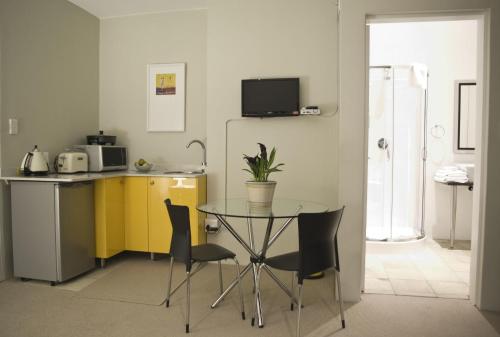a kitchen with a table and two chairs and a sink at Orangerie Guest House in Johannesburg