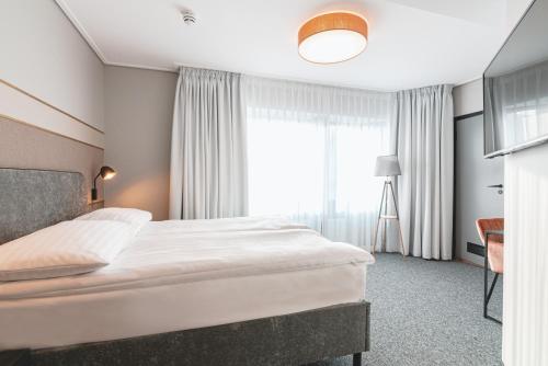 a hotel room with a large bed and a window at Rija Fonnental Design Hotel Tallinn in Tallinn