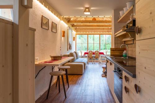 eine Küche und ein Wohnzimmer mit einem Sofa und einem Tisch in der Unterkunft ALPIK Chalets - Bohinj in Bohinj