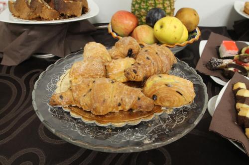 a plate of pastries and apples on a table at Hotel Star in Monterotondo