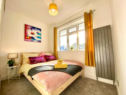 1 dormitorio con cama y ventana en 2 Min Walk to the Best Beach! Stunning Newly Refurbished Stylish 2 Bedroom Apartment! - Great Location - FREE Parking - Fast WiFi - Smart TV - sleeps up to 4! Close to Bournemouth & Poole Town Centre & Sandbanks, en Bournemouth