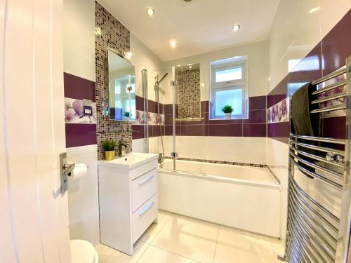 y baño con bañera, aseo y lavamanos. en 2 Min Walk to the Best Beach! Stunning Newly Refurbished Stylish 2 Bedroom Apartment! - Great Location - FREE Parking - Fast WiFi - Smart TV - sleeps up to 4! Close to Bournemouth & Poole Town Centre & Sandbanks, en Bournemouth