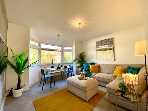 a living room with a couch and a table at 2 Min Walk to the Best Beach! Stunning Newly Refurbished Stylish 2 Bedroom Apartment! - Great Location - FREE Parking - Fast WiFi - Smart TV - sleeps up to 4! Close to Bournemouth & Poole Town Centre & Sandbanks in Bournemouth