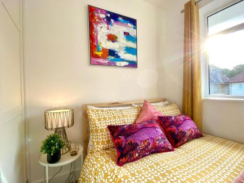 a bedroom with a bed with pillows and a window at 2 Min Walk to the Best Beach! Stunning Newly Refurbished Stylish 2 Bedroom Apartment! - Great Location - FREE Parking - Fast WiFi - Smart TV - sleeps up to 4! Close to Bournemouth & Poole Town Centre & Sandbanks in Bournemouth